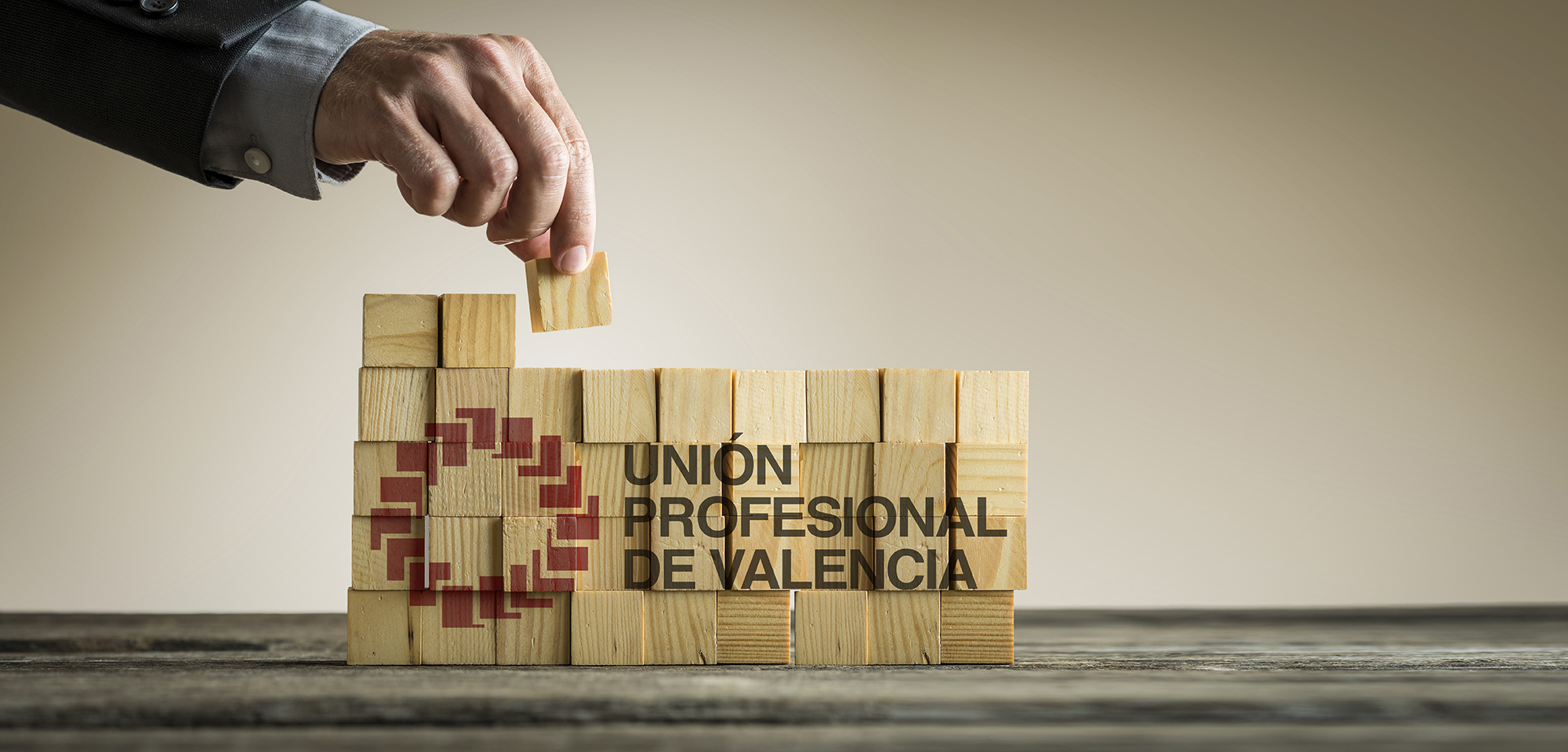 Businessman building a structure with wooden cubes on table surf